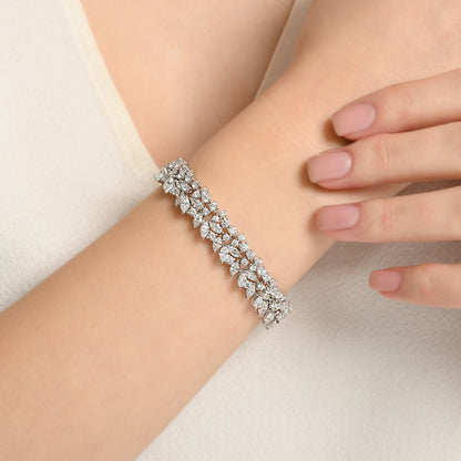 El işçiliğiyle hazırlanmış 14,19 karat markiz pırlanta bilezik, beyaz altının modern görünümüyle birleşerek göz kamaştırıcı bir takı oluşturur.