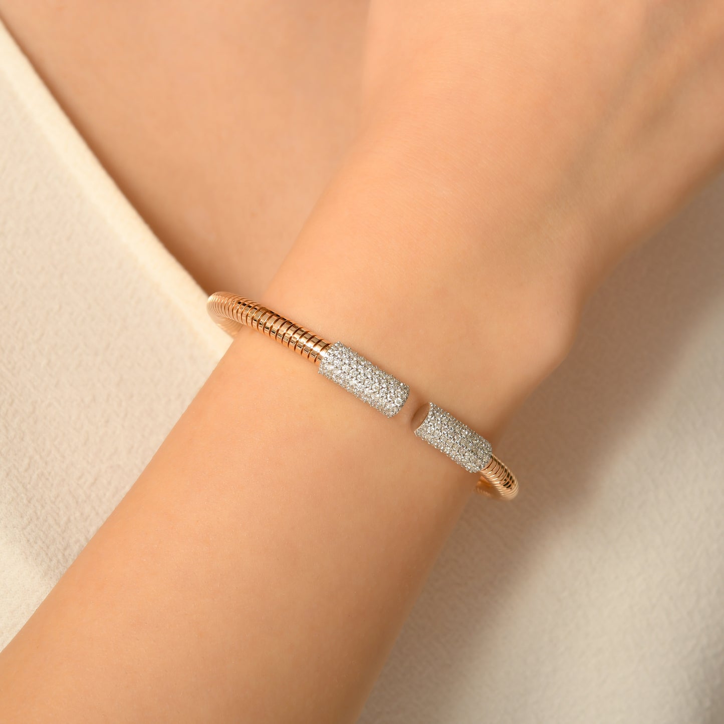 Rose altın bilezik uç kısmındaki beyaz altın pırlanta detaylarıyla göz alıcı bir parlaklık sağlar çünkü taşlar ışığı kusursuz yansıtır.