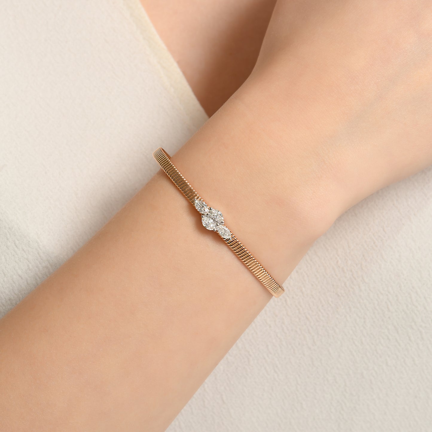 18 ayar rose altın markiz pırlanta bilezik, merkezinde beyaz altın montürle yerleştirilmiş ışıltılı pırlantalarla dikkat çeker. Hem modern hem klasik stil için ideal olan bu tasarım, zarif şıklığı yansıtır.