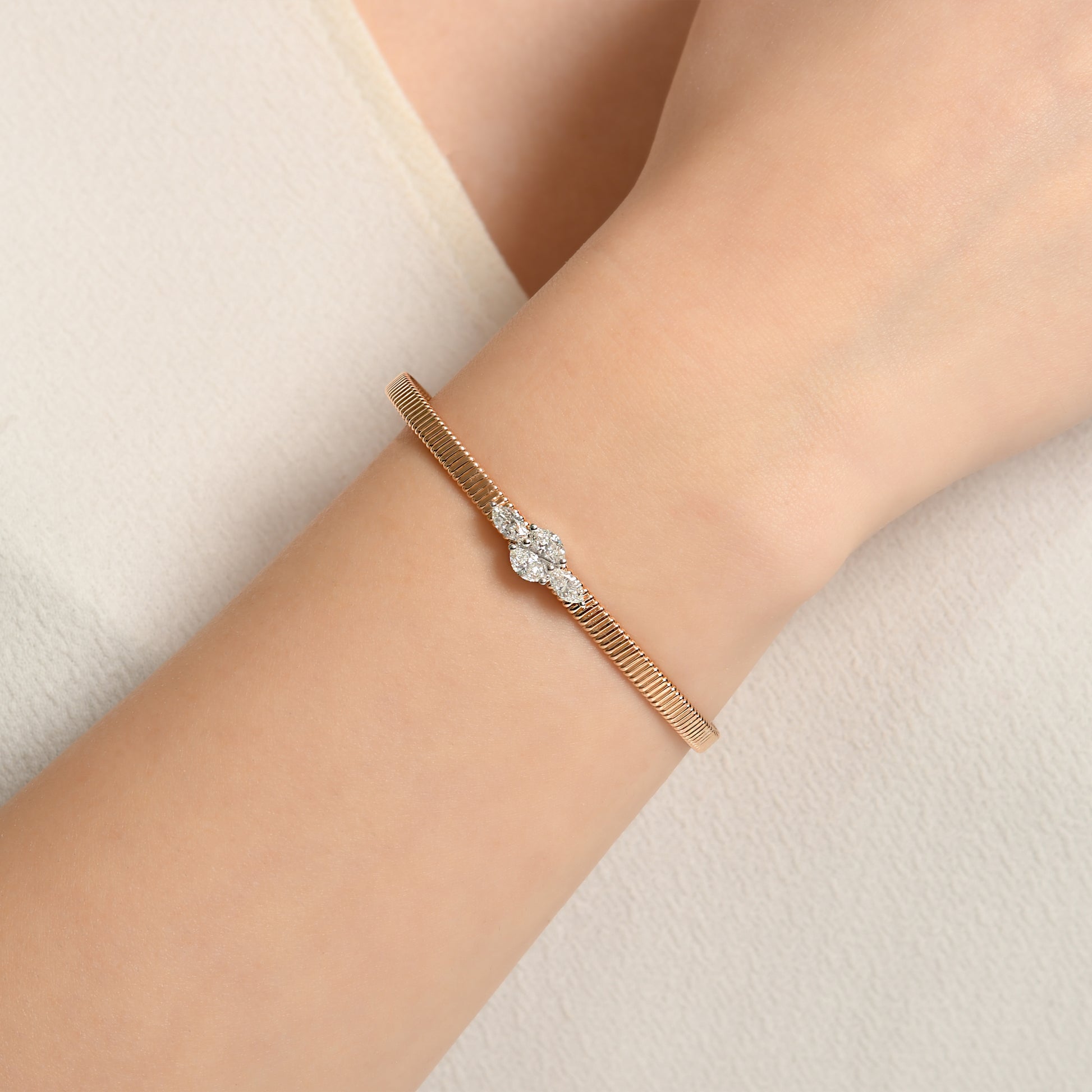 18 ayar rose altın markiz pırlanta bilezik, merkezinde beyaz altın montürle yerleştirilmiş ışıltılı pırlantalarla dikkat çeker. Hem modern hem klasik stil için ideal olan bu tasarım, zarif şıklığı yansıtır.