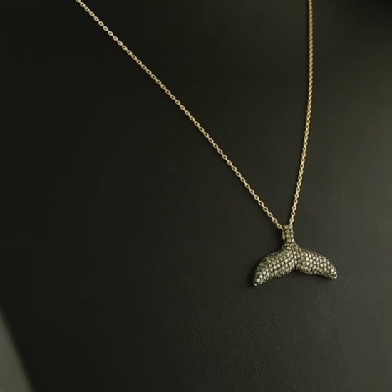 El işçiliğiyle hazırlanan tasarım pırlanta altın kolye, kahverengi pırlantaların parlaklığı ile öne çıkar çünkü taşların her biri dikkatle yerleştirilmiştir. Balık kuyruğu figürüyle minimal tarzı yansıtan bu kahverengi pırlanta kolye, hem günlük kombinlerde hem de özel davetlerde şıklığı artıran nadide bir mücevherdir.