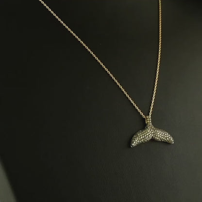 El işçiliğiyle hazırlanan tasarım pırlanta altın kolye, kahverengi pırlantaların parlaklığı ile öne çıkar çünkü taşların her biri dikkatle yerleştirilmiştir. Balık kuyruğu figürüyle minimal tarzı yansıtan bu kahverengi pırlanta kolye, hem günlük kombinlerde hem de özel davetlerde şıklığı artıran nadide bir mücevherdir.