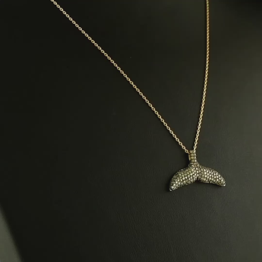 El işçiliğiyle hazırlanan tasarım pırlanta altın kolye, kahverengi pırlantaların parlaklığı ile öne çıkar çünkü taşların her biri dikkatle yerleştirilmiştir. Balık kuyruğu figürüyle minimal tarzı yansıtan bu kahverengi pırlanta kolye, hem günlük kombinlerde hem de özel davetlerde şıklığı artıran nadide bir mücevherdir.