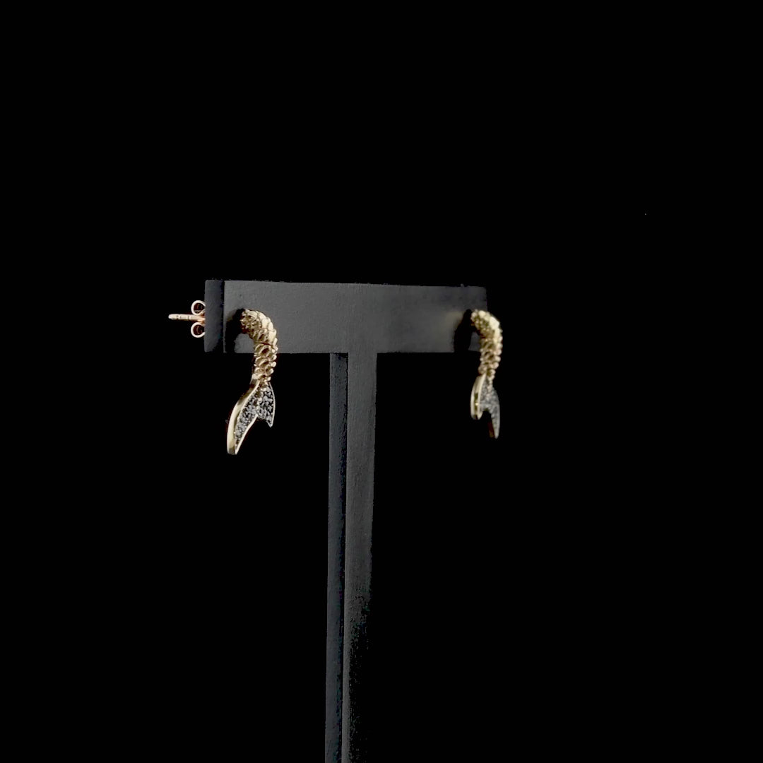 Siyah pırlanta kuyruklu küpe, yalnızca kuyruğunda yer alan taşlarla sofistike bir vurgulama yapar. Rose altın gövdeyle dengelenen bu tasarım, balık figürünü hem sembolik hem estetik şekilde yansıtır. Altın kuyruklu balık küpe modeli, sade takı tercih edenler için ideal bir seçim sunar.

