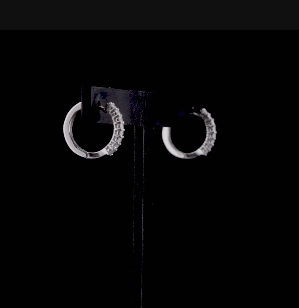 Yarım tur pırlanta halka küpe modeli, beyaz altının sade parlaklığı ve özenle yerleştirilmiş pırlanta taşlarla birleşerek modern bir şıklık yaratır. Küçük boyutu kulakta hafif bir duruş sergilerken, pırlanta dizilimi her açıdan ışıltı sağlar.