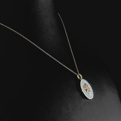 Pırlantalı yonca altın kolyenin yakından çekilmiş detayında, parlak turkuaz minesi ve etrafını çevreleyen 0,16 karat pırlantaların göz alıcı ışıltısı net şekilde görülüyor, zarif işçilik dikkat çekiyor.

